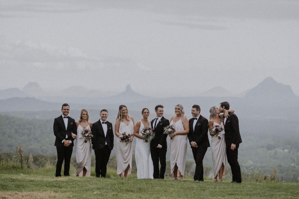 Sunshine Coast wedding party having fun with a stunning back drop of Glass House Mountains in distance.
