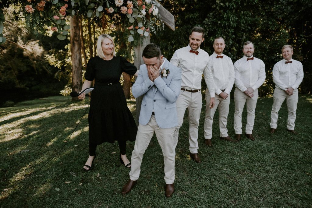 Sunshine Coast Wedding photography, groom reacts to seeing his bride by crying into his hands as his groomsmen look on.