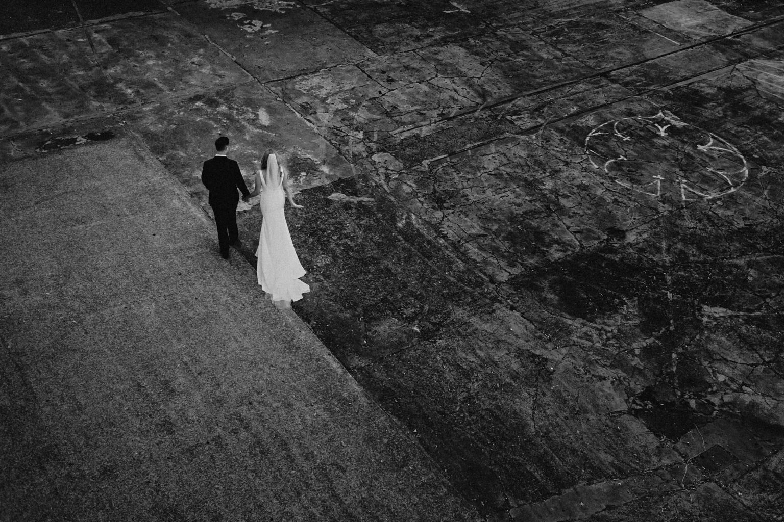 Bride and groom walking across court yard for their Brisbane Wedding at the Powerhouse.