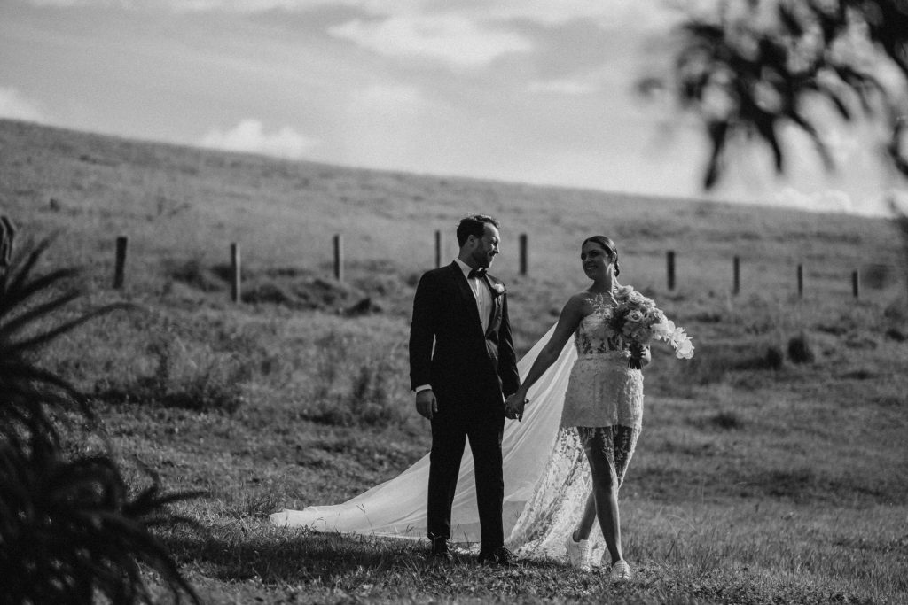 Bride and groom walking together down a hill at Forget Me not Farm